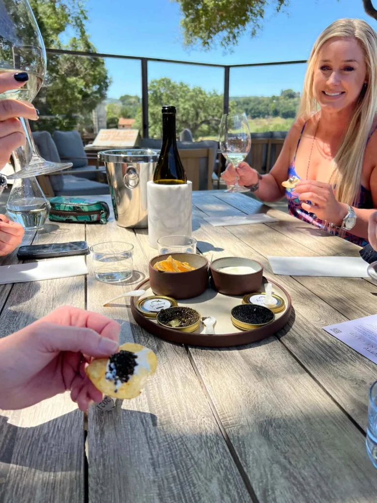 caviar and wine being served on a patio